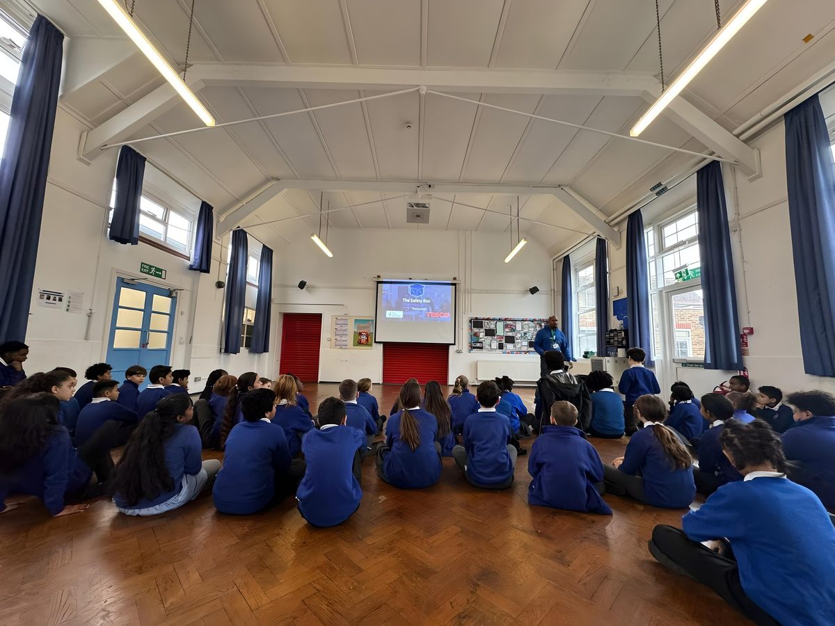 A full school hall of pupils watching a One Decision presentation